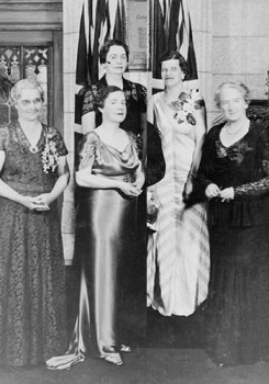 Foto da inauguração da placa comemorativa em homenagem as Cinco mulheres de Alberta, cuja luta garantiu às mulheres canadenses o direito de exercer cargos no Senado canadense. Nellie McClung na fila da frente à direita. Foto disponível na Wikimedia Commons em CC. 