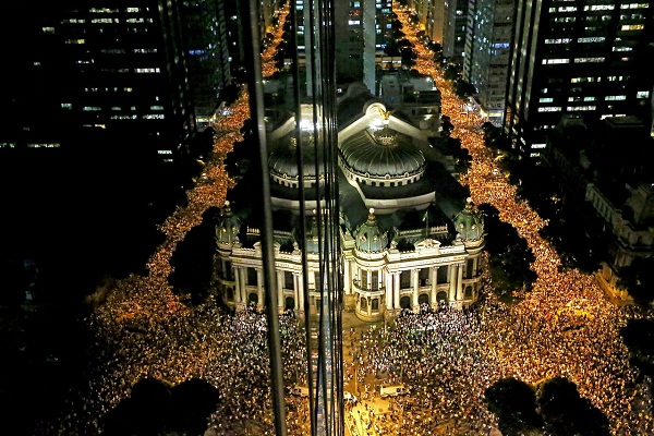 17 de junho - Reflexo em fachada de prédio mostra o protesto contra o aumento da passagem de ônibus no Rio de Janeiro, pela Avenida Rio Branco, chegando ao Teatro Municipal, no centro da cidade. Foto de Fabio Motta/ Estadão.