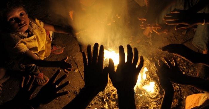 Moradores de rua se aquecerem em volta de fogueira em Calcutá, Índia. Foto de Deshakalyan Chowdhur/AFP.