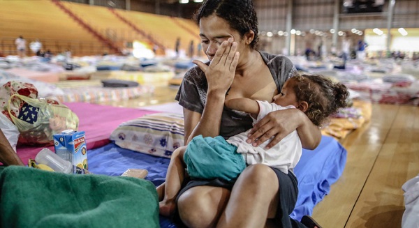 Mulher e criança, desabrigadas após o rompimento da barragem de rejeitos da mineradora Samarco, em um abrigo em Mariana, interior de Minas Gerais. Foto de Cristiane Mattos/Futura Press/Estadão.